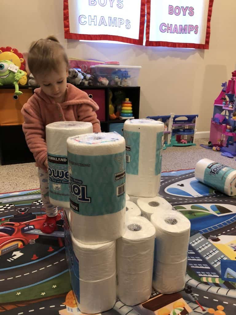 Building towers with paper towel and toilet paper rolls is fun for toddlers because they can knock them down and fall on top of them.