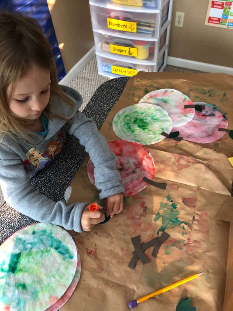 Engage your preschooler in this easy apple art project perfect for apple-themed learning. Build fine motor skills, talk about the parts of an apple and colors of apples. Decorate your home with the finished product. 